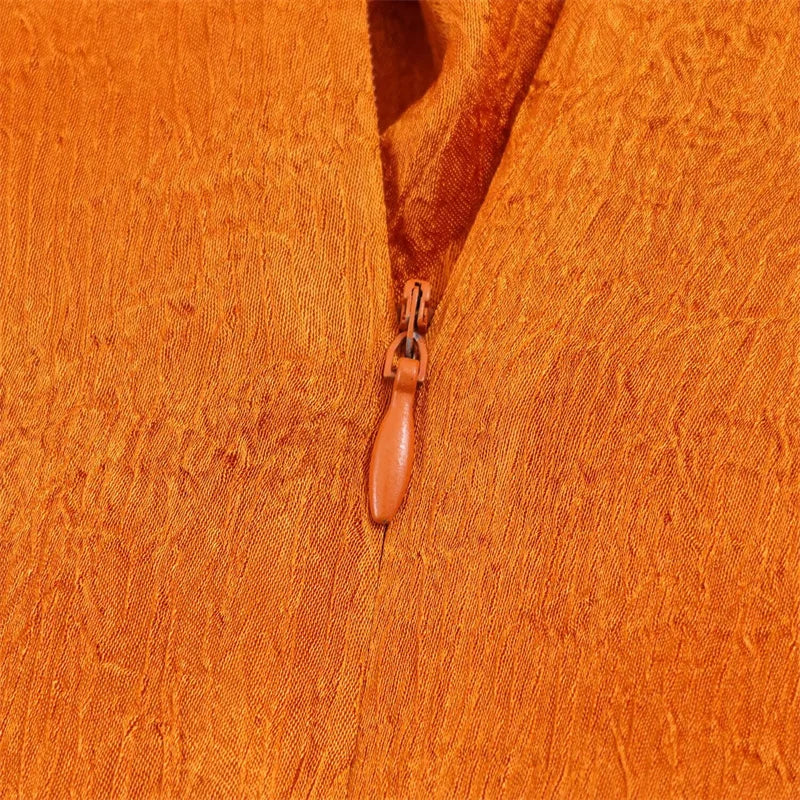 Women's top, Spring 2026 novelty: orange sleeveless design with satin texture and long tie; an elegant, stylish, and unique garment that sets the trend.