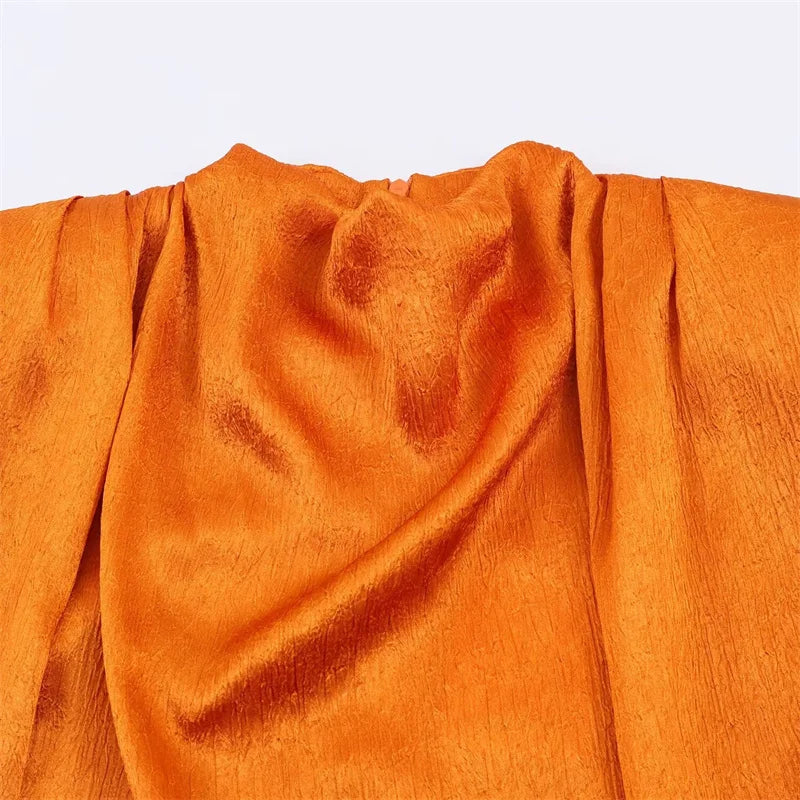 Women's top, Spring 2026 novelty: orange sleeveless design with satin texture and long tie; an elegant, stylish, and unique garment that sets the trend.
