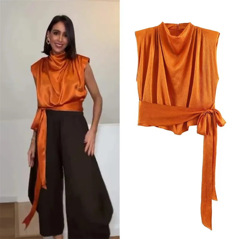 Women's top, Spring 2026 novelty: orange sleeveless design with satin texture and long tie; an elegant, stylish, and unique garment that sets the trend.